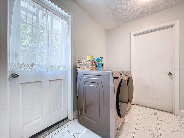 washroom with washing machine and clothes dryer, laundry area, a textured ceiling, and marble finish floor