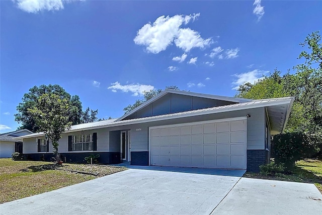 single story home with concrete driveway, board and batten siding, brick siding, and a garage