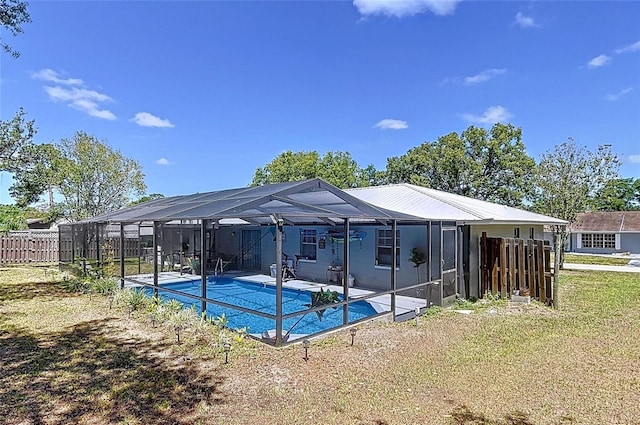 exterior space featuring a lawn, fence, a patio, an outdoor pool, and a lanai