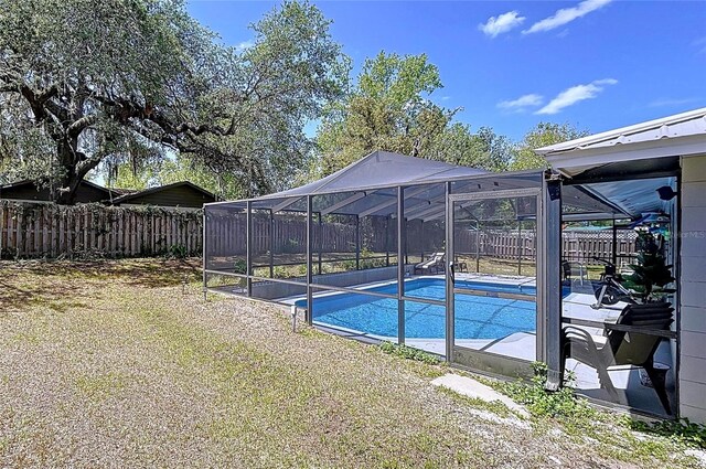 view of pool featuring a yard, a lanai, a fenced in pool, and a fenced backyard