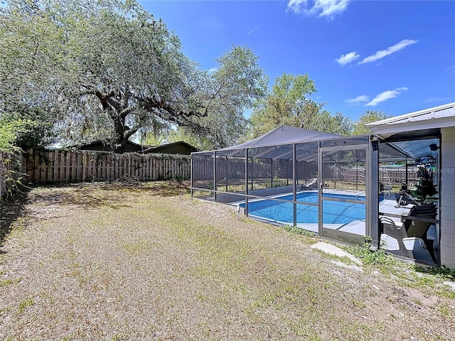 view of pool with a fenced backyard, a lanai, a fenced in pool, and a yard