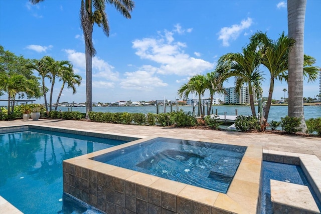 view of pool featuring a water view and an in ground hot tub