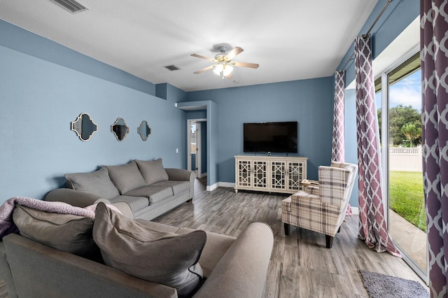 living room with a ceiling fan, baseboards, visible vents, and wood finished floors