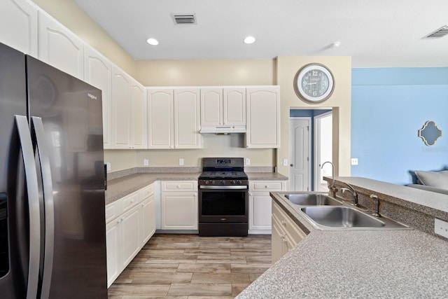 2808 Abbey Grove Dr, Valrico, FL 33594 - kitchen with stainless steel fridge with ice dispenser, range with gas stovetop, under cabinet range hood, light wood-style flooring, and white cabinets