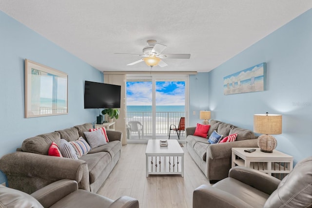 18650 Gulf Blvd Unit 203, Indian Shores, FL 33785 - living area featuring ceiling fan, light wood-style floors, a wall of windows, and a textured ceiling