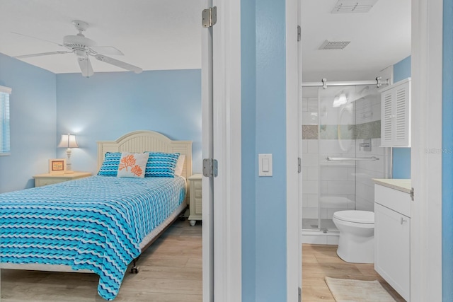 18650 Gulf Blvd Unit 203, Indian Shores, FL 33785 - bedroom featuring light wood-type flooring, ensuite bathroom, and ceiling fan