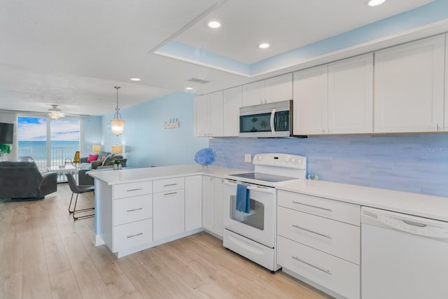 18650 Gulf Blvd Unit 203, Indian Shores, FL 33785 - kitchen featuring white appliances, a peninsula, open floor plan, backsplash, and white cabinetry