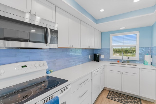 18650 Gulf Blvd Unit 203, Indian Shores, FL 33785 - kitchen with white appliances, a sink, light countertops, white cabinetry, and recessed lighting