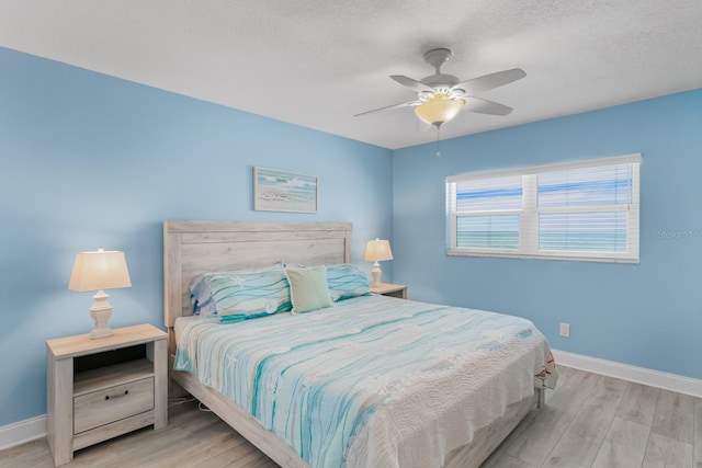 18650 Gulf Blvd Unit 203, Indian Shores, FL 33785 - bedroom with wood finished floors, baseboards, ceiling fan, and a textured ceiling