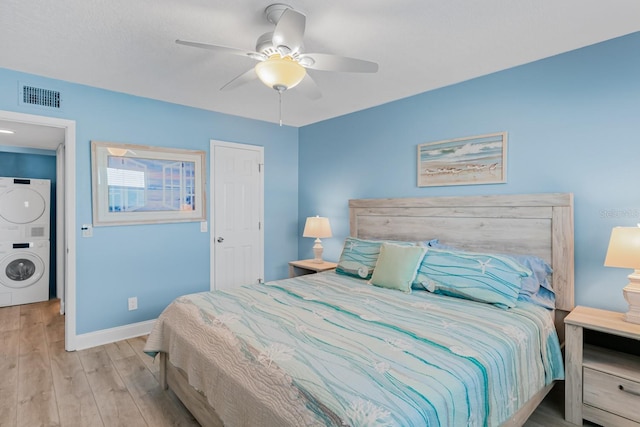 18650 Gulf Blvd Unit 203, Indian Shores, FL 33785 - bedroom with stacked washer / drying machine, wood finished floors, baseboards, and ceiling fan