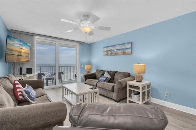 18650 Gulf Blvd Unit 203, Indian Shores, FL 33785 - living area with wood finished floors, a ceiling fan, and a water view