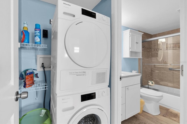 18650 Gulf Blvd Unit 203, Indian Shores, FL 33785 - laundry area featuring stacked washing machine and dryer and wood finished floors