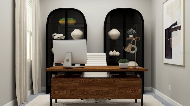 carpeted office space featuring baseboards