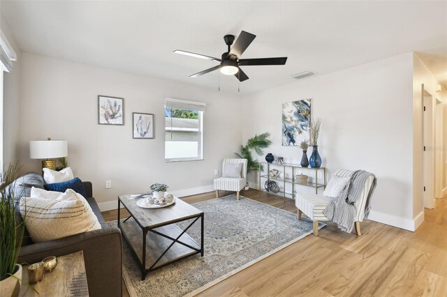 living room with ceiling fan, wood finished floors, and baseboards