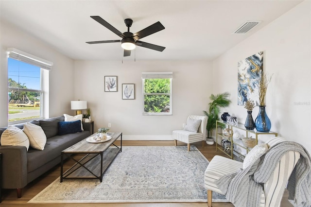 living area with ceiling fan, wood finished floors, and baseboards
