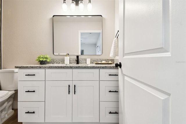 bathroom featuring toilet and vanity