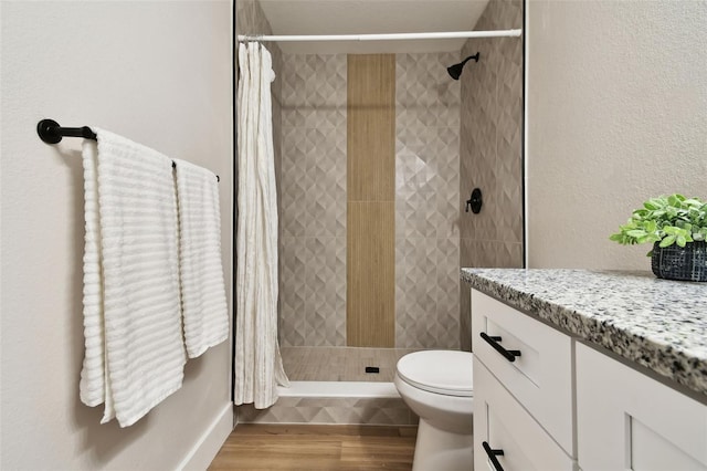 full bathroom with a shower stall, wood finished floors, and toilet