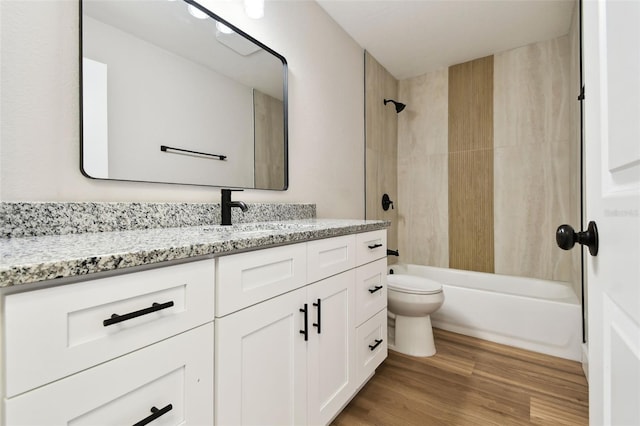 full bath with toilet, vanity, bathing tub / shower combination, and wood finished floors