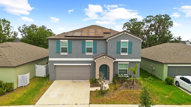 view of front of property with driveway, stucco siding, a front yard, and roof mounted solar panels