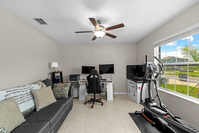 office with light tile patterned floors, visible vents, baseboards, and a ceiling fan