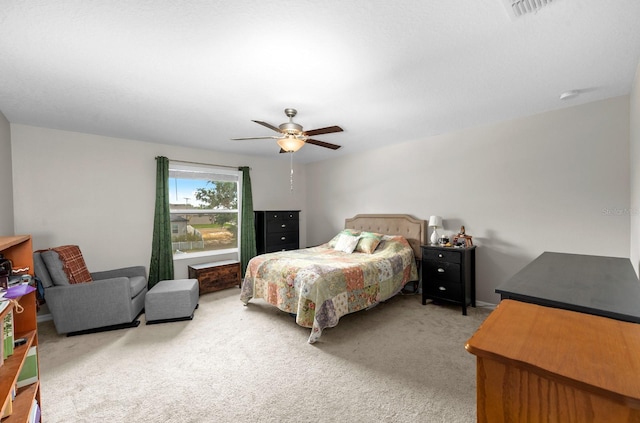 bedroom featuring a ceiling fan, visible vents, and light colored carpet