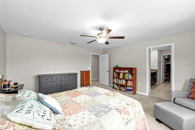 bedroom featuring a ceiling fan, visible vents, baseboards, light colored carpet, and a spacious closet