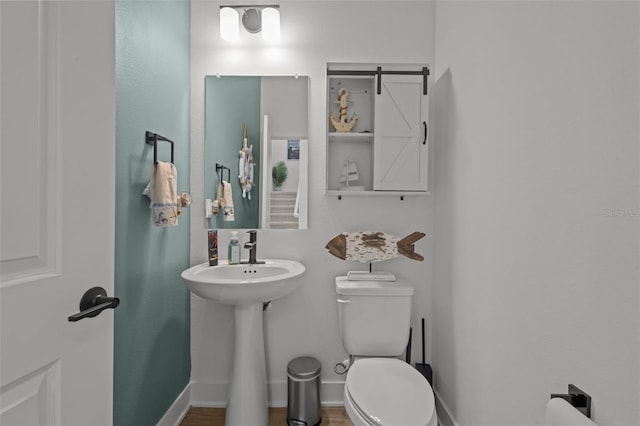 half bath featuring toilet and baseboards