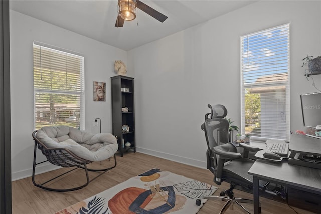 office featuring a ceiling fan, baseboards, plenty of natural light, and wood finished floors