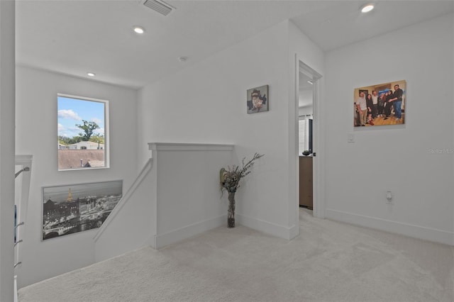 hallway featuring recessed lighting, an upstairs landing, visible vents, and carpet