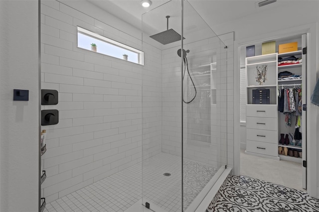 bathroom featuring a stall shower and a walk in closet