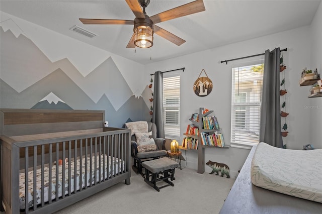 carpeted bedroom with multiple windows, visible vents, and a ceiling fan