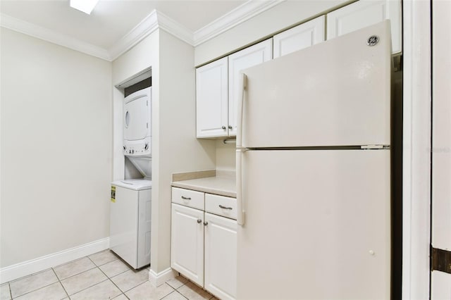 kitchen featuring freestanding refrigerator, stacked washer / drying machine, crown molding, light countertops, and white cabinets