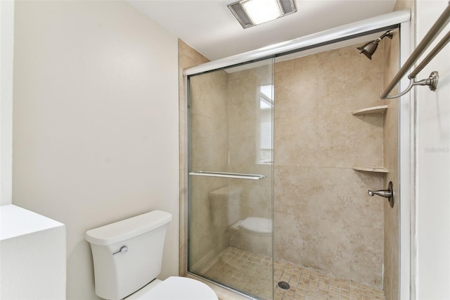 bathroom with toilet and a shower stall