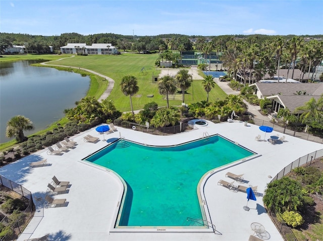 view of swimming pool with a water view and view of wooded area