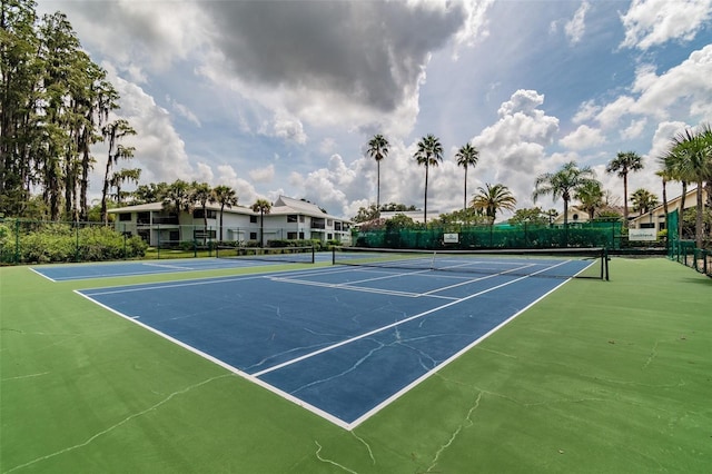 view of tennis court featuring fence and community basketball court
