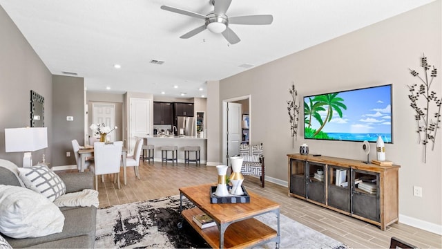 living room with visible vents, baseboards, ceiling fan, wood finish floors, and recessed lighting