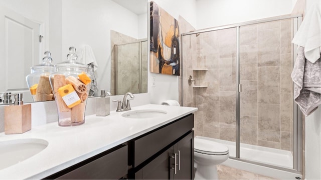 bathroom featuring toilet, a sink, a shower stall, tile patterned flooring, and double vanity