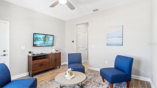 living area with ceiling fan, visible vents, and wood finish floors