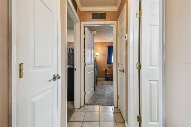 8531 Woodcrest Dr, Port Richey, FL 34668 - hall with a textured ceiling, light carpet, crown molding, light tile patterned flooring, and baseboards