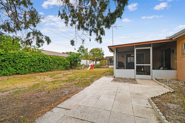 8531 Woodcrest Dr, Port Richey, FL 34668 - view of grassy yard with a sunroom, a playground, and a patio