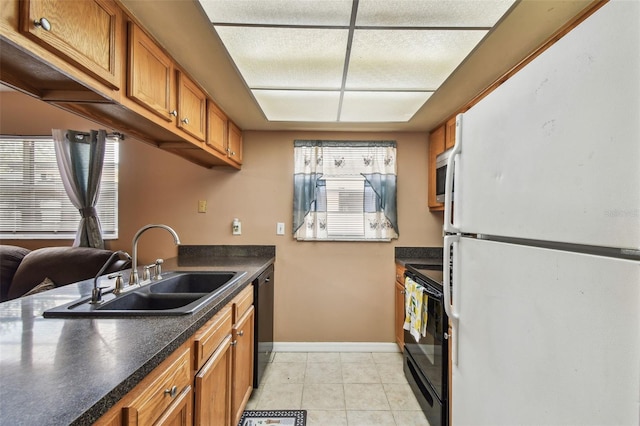 8531 Woodcrest Dr, Port Richey, FL 34668 - kitchen featuring black appliances, a sink, brown cabinetry, dark countertops, and baseboards