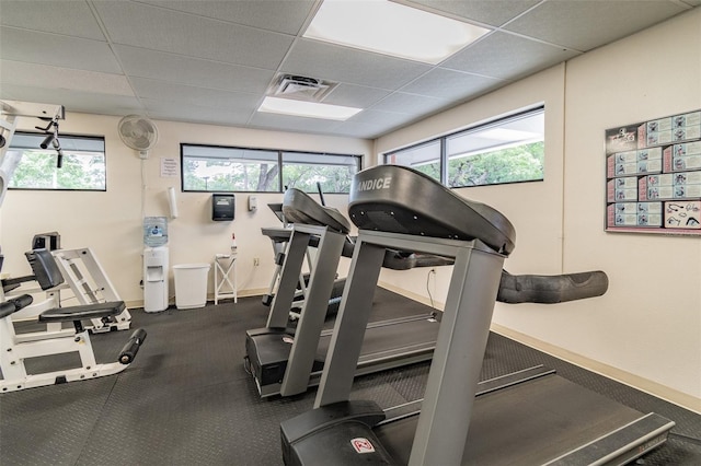 8531 Woodcrest Dr, Port Richey, FL 34668 - exercise room featuring a paneled ceiling, baseboards, and healthy amount of natural light