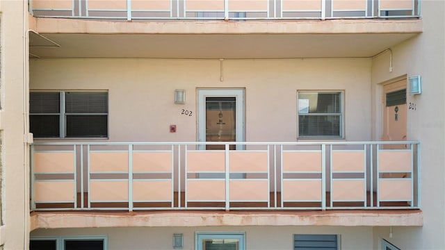 doorway to property featuring a balcony and stucco siding