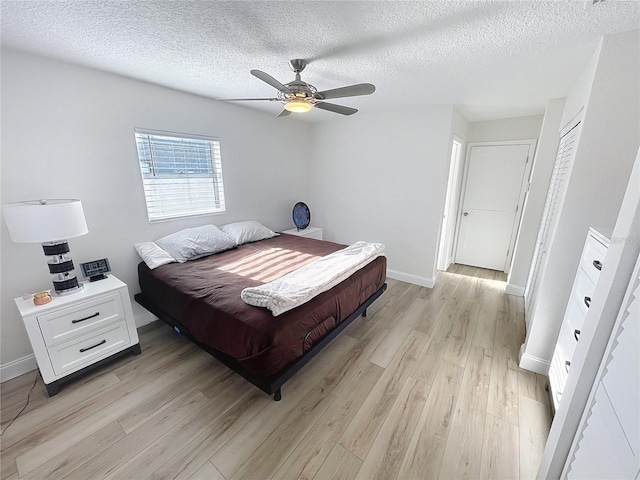 4715 W Chapin Ave, Tampa, FL 33611 - bedroom featuring light wood finished floors, a textured ceiling, baseboards, and ceiling fan