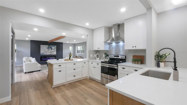 1715 N Alexander Rd, Tampa, FL 33603 - kitchen featuring stainless steel electric range, a sink, light wood-style flooring, wall chimney exhaust hood, and a peninsula