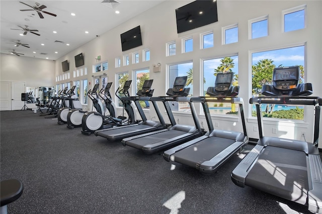 workout area featuring ceiling fan, a towering ceiling, and recessed lighting