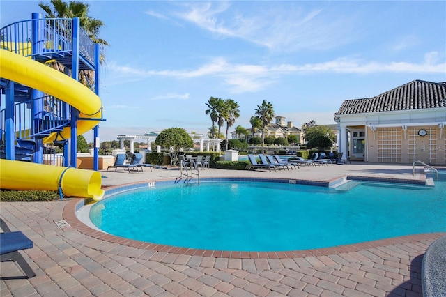 pool with a patio and a water slide