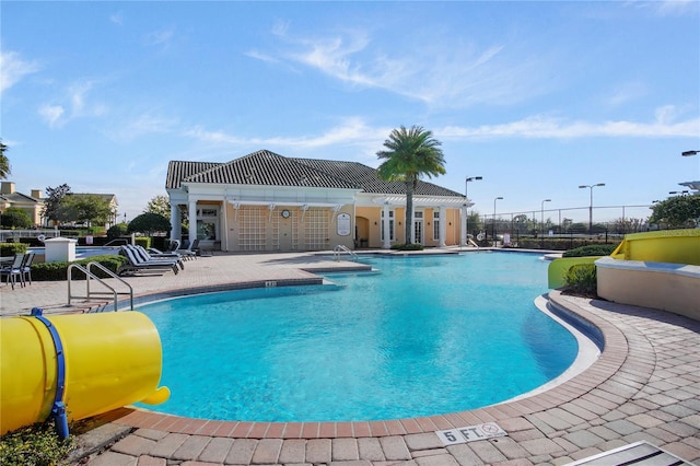 community pool with fence and a patio area