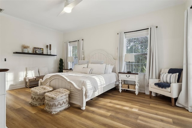 bedroom with wood finished floors, a ceiling fan, and ornamental molding