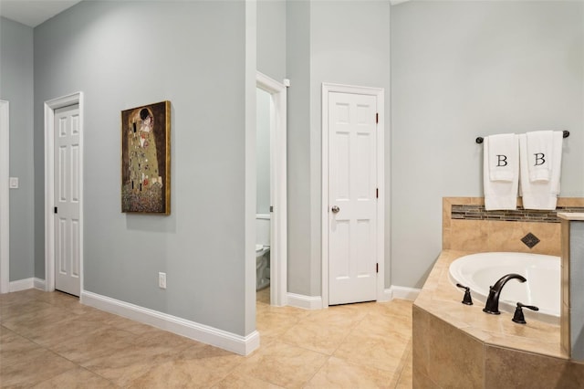 full bathroom featuring a bath, a towering ceiling, baseboards, toilet, and a closet